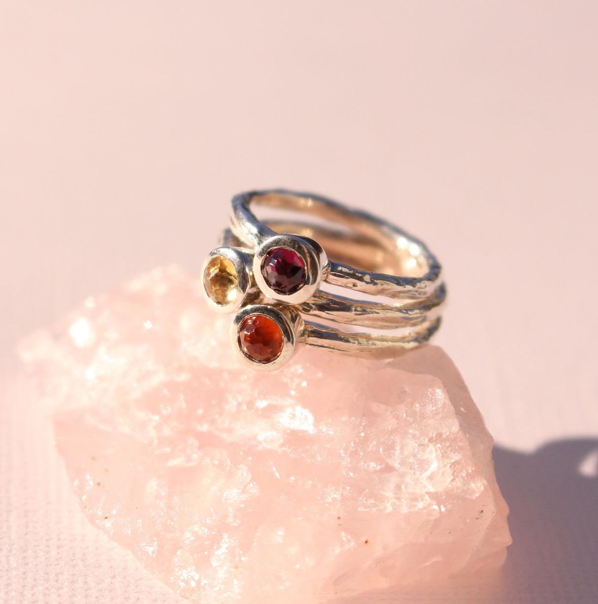 Organic rose cut coloured gemstone rings stacked together.