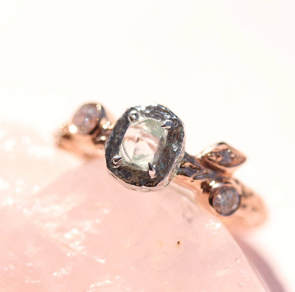 Rough diamond engagement ring on rose quartz rock