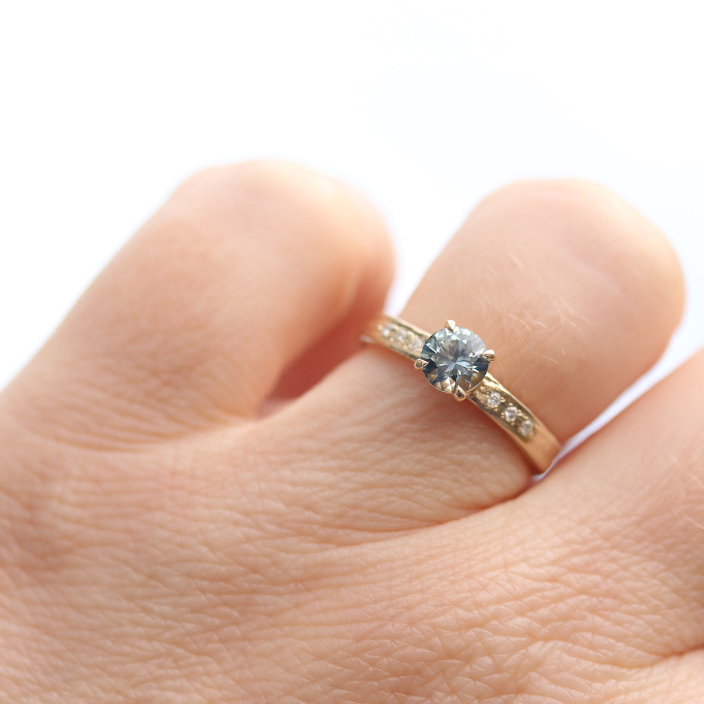 Teal sapphire ring modelled on the finger by jewelry designer Kathryn Rebecca