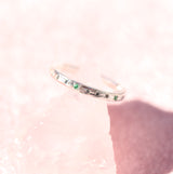 Water band in silver with teal sapphire and emerald