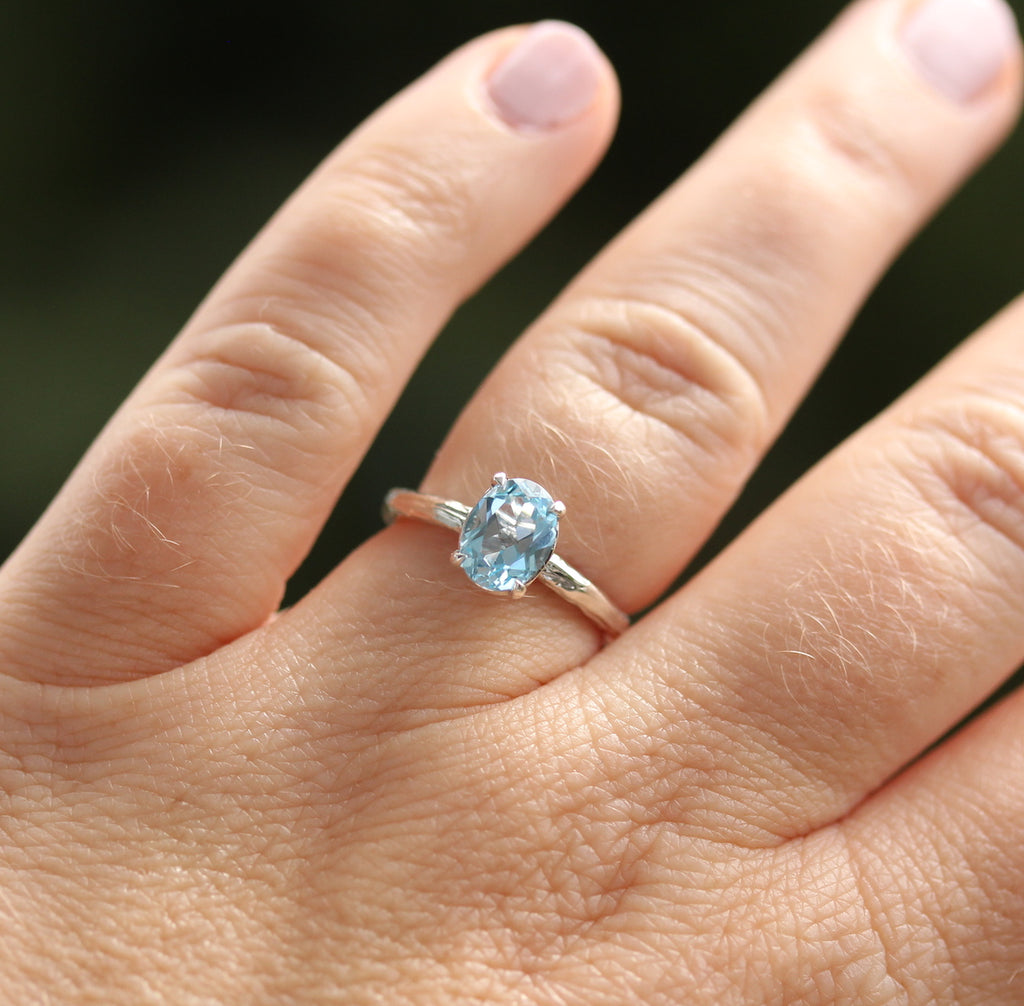 blue topaz oval gemstone ring on the hand