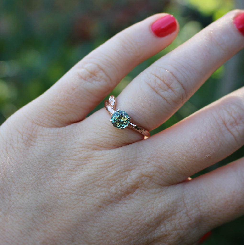 Rose gold and green sapphire ring on a hand