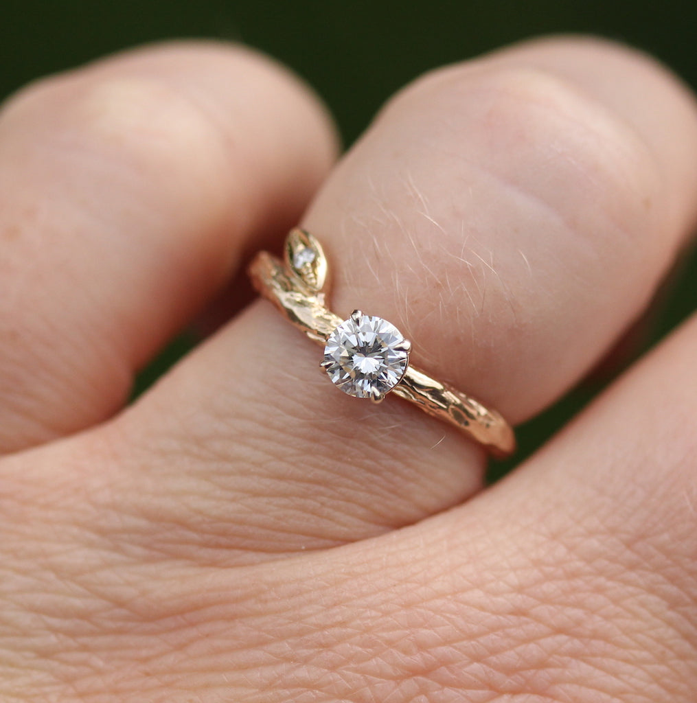 organic engagement ring on finger