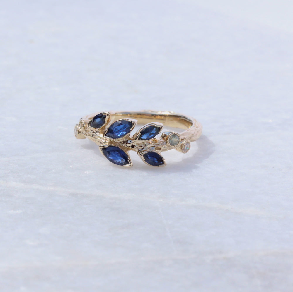 Yellow gold ring with blue sapphire leaf design