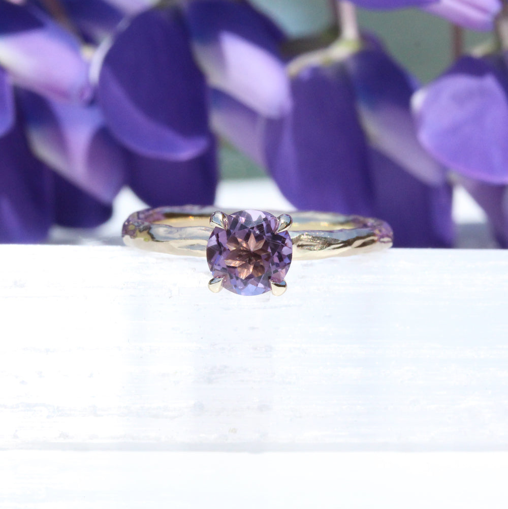 Amethyst ring with purple flowers in background