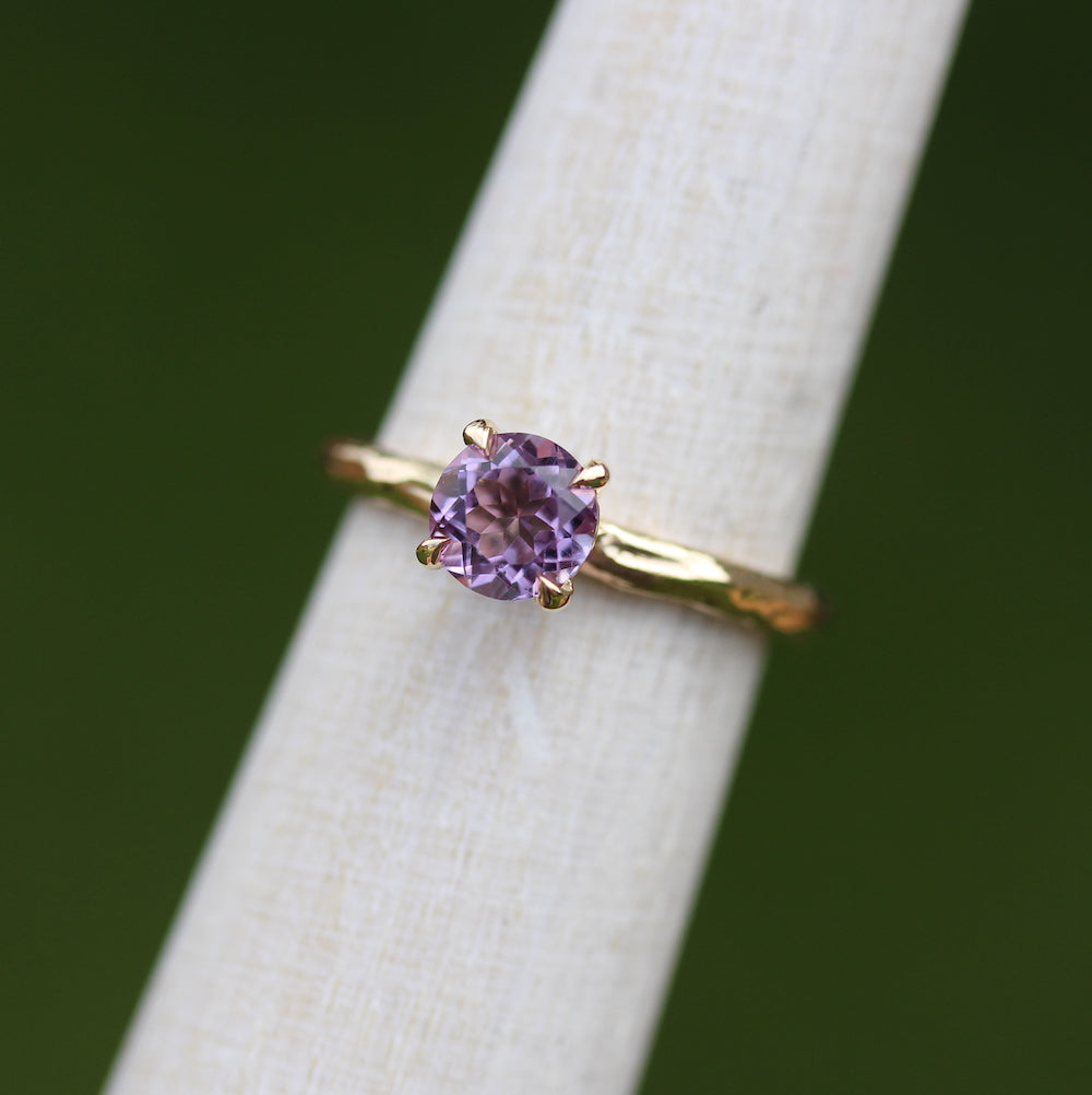 Purple Amethyst ring with yellow gold band on a ring mandrel