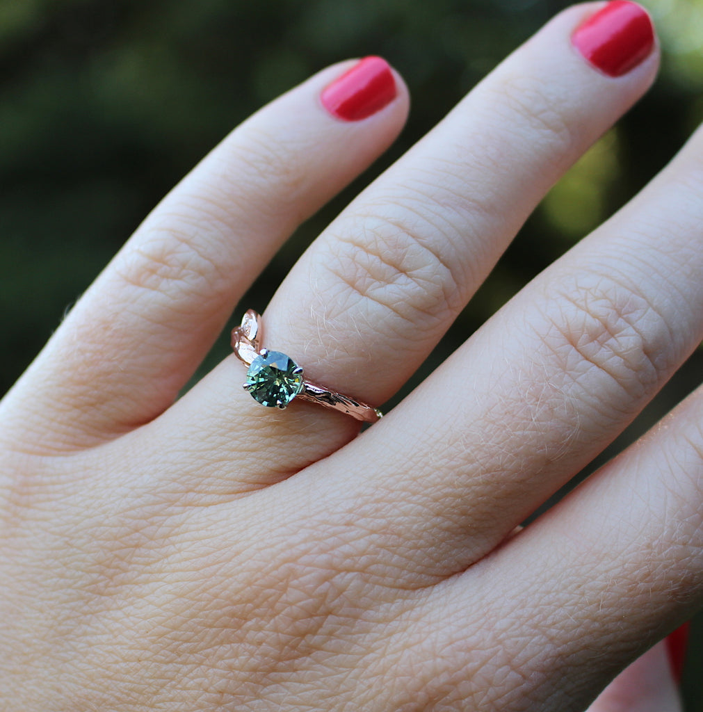 Green sapphire and rose gold ring on a hand