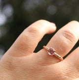 pink garnet solitaire on the finger