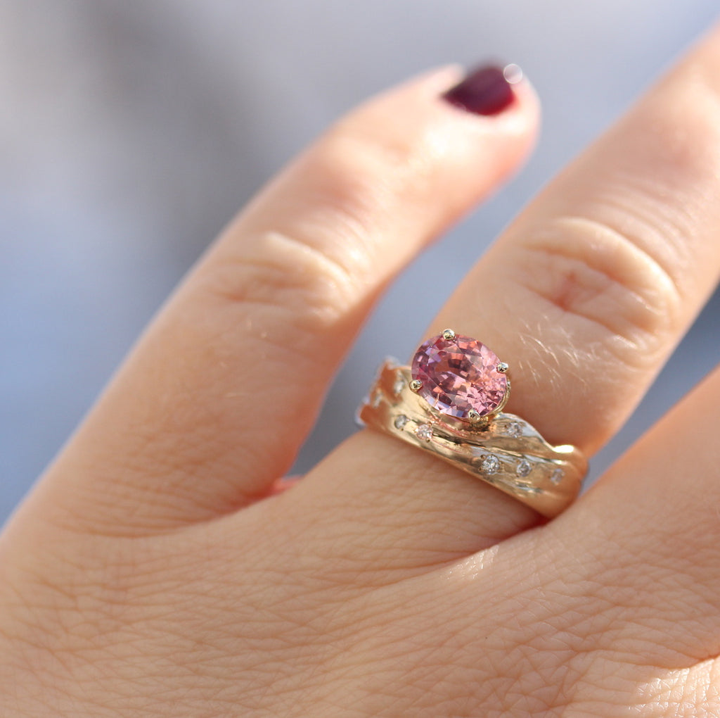 diamond and pink gemstone ring on the finger